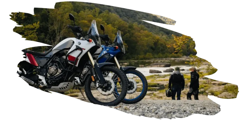 Two yamaha motorcycles parked while their drivers look at the river